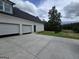 Exterior view showcasing the garage doors, driveway, side door, and well-manicured lawn at Lot C Montannas Way, Moreland, GA 30259
