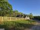 The home is surrounded by green grass and a wooden fence, blending seamlessly with the natural landscape at Lot C Montannas Way, Moreland, GA 30259