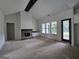 Bright living room featuring a brick fireplace, beam, and windows providing ample natural light at Lot C Montannas Way, Moreland, GA 30259
