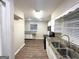 Well-lit kitchen featuring granite countertops, stainless steel sink, sleek black appliances, and wood laminate flooring at 2634 Rockcliff Se Rd, Atlanta, GA 30316