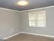 A gray bedroom with light wood-look floors and a window at 3083 Colonial Way # N, Atlanta, GA 30341