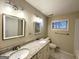 Bathroom featuring double sinks, granite countertops, modern light fixtures, and a vanity mirror at 3403 Dodson Ter, East Point, GA 30344