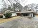 Single-story home with a covered carport, a front porch, and a mature bush in front of the residence at 3403 Dodson Ter, East Point, GA 30344