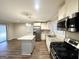 Open-concept kitchen featuring granite countertops, stainless steel appliances, wooden floors, and natural light at 3403 Dodson Ter, East Point, GA 30344