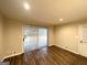 An empty living room with wood laminate flooring and sliding glass doors with vertical blinds at 3403 Dodson Ter, East Point, GA 30344