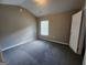 Bright bedroom featuring neutral tones, a gray carpet, and a window for natural light at 5725 Cedar Pass, Fairburn, GA 30213