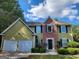 Two-story home with brick and siding, features an attached two-car garage and manicured landscaping at 5725 Cedar Pass, Fairburn, GA 30213