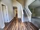 Bright foyer with wood-look flooring and a staircase with white risers and a neutral gray carpet at 5725 Cedar Pass, Fairburn, GA 30213