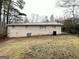 View of the backyard showcasing the exterior of the home with mature trees at 4954 Springbrook Dr, Douglasville, GA 30135