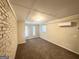 Finished basement with painted brick accent wall, carpeted floors, and paneled walls at 4954 Springbrook Dr, Douglasville, GA 30135