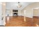 Spacious living room featuring hardwood floors, a ceiling fan, and a cozy stone fireplace at 3411 Airline Rd, Mcdonough, GA 30252