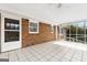 Covered screened porch with brick walls, tiled floor, and ceiling fan at 3411 Airline Rd, Mcdonough, GA 30252