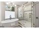 Bright bathroom features a sleek bathtub, a glass shower, and a modern chandelier for a spa-like experience at 1055 Ormewood Se Ave, Atlanta, GA 30316