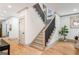 Bright entryway featuring hardwood floors, stylish staircase, and a view of the hallway with neutral wall colors at 1055 Ormewood Se Ave, Atlanta, GA 30316