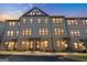 Townhome building at dusk showcasing the brick facade, large windows, and welcoming entrance lights at 2624 Caruso Way, Atlanta, GA 30339