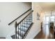 Staircase with hardwood steps and black iron spindles; leads to a bright hallway at 2624 Caruso Way, Atlanta, GA 30339