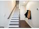 Well-lit staircase with hardwood steps and white risers and adjacent coatrack at 2624 Caruso Way, Atlanta, GA 30339