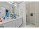 Bathroom featuring a double vanity with a framed mirror, wallpaper, and a shower behind a curtain at 40 Berkshire Run, Covington, GA 30016