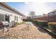A backyard with a brick patio, wooden fence, grill, table, and chairs against a blue sky at 7764 Parkside Dr, Lithia Springs, GA 30122