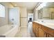 Bright bathroom featuring a double sink vanity, bathtub, and a separate shower stall at 7764 Parkside Dr, Lithia Springs, GA 30122