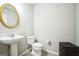 Powder room features modern vanity with pedestal sink and a gold framed mirror at 7764 Parkside Dr, Lithia Springs, GA 30122