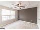 Bright bedroom with neutral walls, carpet floor, a ceiling fan, and natural light at 7764 Parkside Dr, Lithia Springs, GA 30122