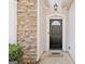 Close up of the house front door with stone accents, a welcome mat and green shrubs at 7764 Parkside Dr, Lithia Springs, GA 30122