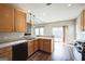 Well-lit kitchen boasts wooden cabinets, stainless steel appliances, dark wood floors, and a bar counter at 7764 Parkside Dr, Lithia Springs, GA 30122