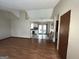 An open living room featuring wood-look floors, white walls, and an entry into the kitchen at 7619 Ward Ln, Jonesboro, GA 30236