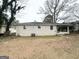 View of the house's brick exterior in the spacious backyard with patio, featuring mature trees and an air conditioning unit at 1785 San Gabriel Ave, Decatur, GA 30032