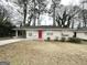 Inviting single-story home featuring a bright red front door, covered carport, and manicured landscaping at 1785 San Gabriel Ave, Decatur, GA 30032