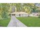 Charming single-story home with a well-manicured lawn and covered carport surrounded by lush green trees at 1785 San Gabriel Ave, Decatur, GA 30032