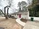 Ranch-style home with a red door, sidewalk, and mature trees in the front yard at 1986 Bandera Dr, Decatur, GA 30032