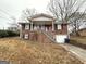 Charming brick home featuring a covered front porch and well-maintained landscaping at 3174 Kingston Nw Rd, Atlanta, GA 30318