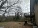 Backyard view from beneath a home's wood deck showing a yard full of leaves and trees beyond at 6982 Knollwood Dr, Morrow, GA 30260