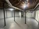 Spacious unfinished basement with gray painted concrete floor, exposed ceiling, and support beams at 6982 Knollwood Dr, Morrow, GA 30260