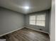 Bedroom with modern wood-look flooring, neutral paint, and natural light from a window at 6982 Knollwood Dr, Morrow, GA 30260