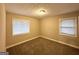 Comfortable bedroom with neutral walls, carpet floors, and two windows for ample light at 1761 Carter Cir, East Point, GA 30344