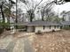 Ranch-style home features a carport, brick exterior, and a yard with mature trees at 1761 Carter Cir, East Point, GA 30344