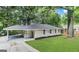 Charming ranch home with a lush lawn, carport, and mature trees surrounding the property at 1761 Carter Cir, East Point, GA 30344