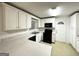 Well-lit kitchen with white cabinetry, black appliances, and ample countertop space at 2537 Bonnybrook Sw Dr, Atlanta, GA 30311
