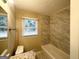Clean bathroom with granite vanity, new tile in the shower, and plenty of natural light from the window at 2544 Brentwood Rd, Decatur, GA 30032