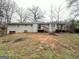 Back view of a single-story house with a grey exterior, a chimney, and a wooden deck overlooking the yard at 3976 Bright Star Rd, Douglasville, GA 30135