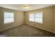 A bedroom with tan walls, carpeted floor, and two windows with white blinds providing natural light at 3976 Bright Star Rd, Douglasville, GA 30135