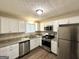 Modern kitchen featuring stainless steel appliances, granite countertops, and ample white cabinetry at 4305 Old Lake Dr, Decatur, GA 30034
