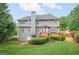 A well-maintained backyard with a wooden deck, lush green grass, and mature trees providing shade and privacy for outdoor enjoyment at 6410 E Hills Ct, Cumming, GA 30041
