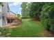 Large backyard showcasing a patio, lush green lawn, mature trees and landscaping, providing ample space for outdoor activities and privacy at 6410 E Hills Ct, Cumming, GA 30041