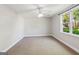 Bedroom with neutral carpet, a ceiling fan and a large window showing exterior greenery at 6410 E Hills Ct, Cumming, GA 30041