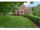 Charming two-story brick home with a red front door and well-manicured lawn, surrounded by mature trees in a lush neighborhood at 6410 E Hills Ct, Cumming, GA 30041