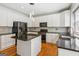 Open kitchen features an island, stainless appliances, and custom white cabinets at 6410 E Hills Ct, Cumming, GA 30041
